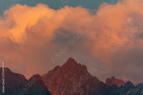 Jagged Mountain Peak at Sunset With Dramatic Orange Clouds and Golden Alpine Light