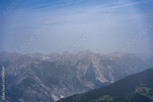 Alpine Mountain Peaks and Rugged Ridge Landscape Under a Hazy Blue Sky Panorama