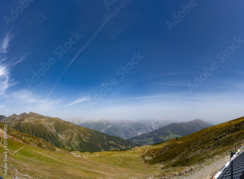 Panoramic Alpine Mountain Valley With Hiking Trails Under Clear Blue Sky