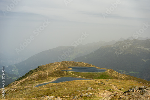 Alpine Mountain Landscape With Winding Trail and Small Lakes Overlooking Remote Valley