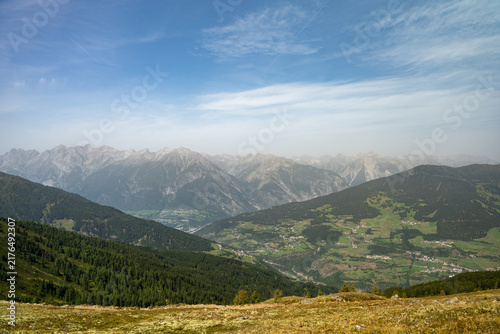 Panoramic Alpine Mountain Landscape With Valley Villages, Forested Slopes and Blue Sky