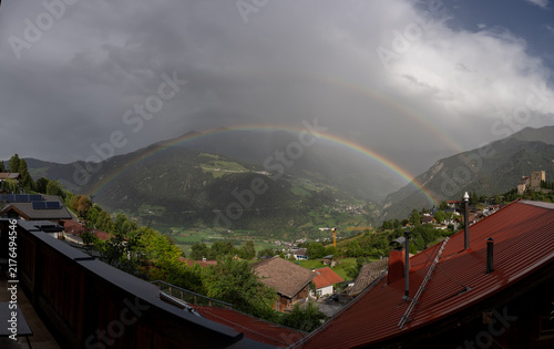 Double Rainbow Over Mountain Village and Green Valley After Storm With Dramatic Clouds