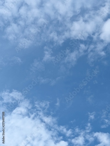 Wall Mural Soft clouds in a vibrant blue summer sky