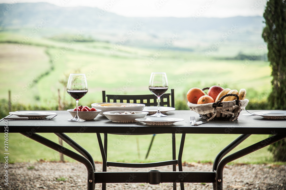Naklejka premium lunch with a view - table against beautiful landscape in Tuscany