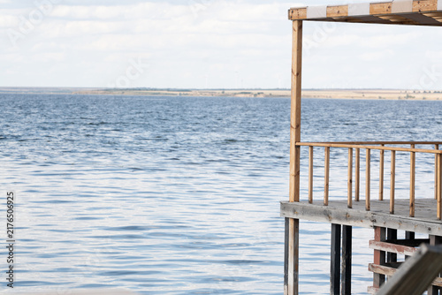 Wooden deck extending over the blue Tiligul Estuary water under a clear sky during the day providing a peaceful place for relaxing by the shore