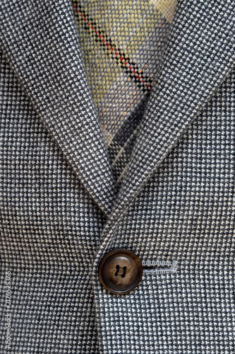 Photography Closeup of light grey woollen buttoned jacket with brown woven tie