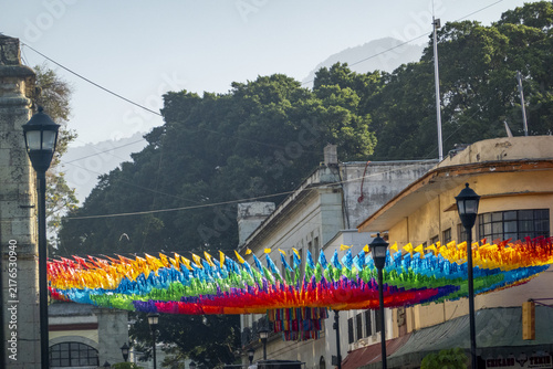 View of colorful papel picado flags strung across a street in Oaxaca, Oaxaca, Mexico.