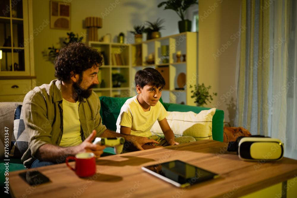 Obraz premium Father and son bonding playing video games at home