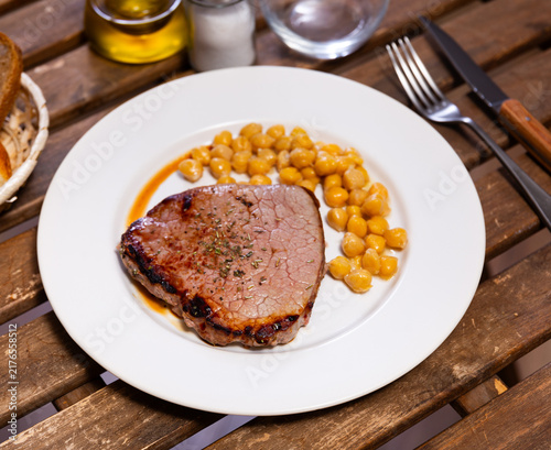 Obraz na płótnie Slice of beef steak on plate with vegetable side dish, stewed chickpea