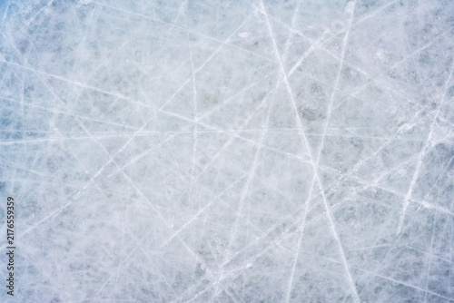 Ice background with marks from skating and hockey, blue texture of rink surface with scratches