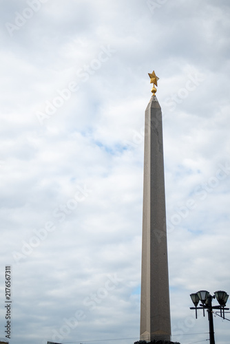 Fotografía Monumental granite stone obelisk tower with golden star on top close up