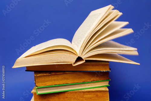 Cuadro en lienzo An open book rests on top of a stack of closed hardcover books for a back to sch