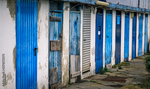 Cuadro en lienzo Weathered blue wooden doors on fisherman sheds in the old port of Sanremo, Italy