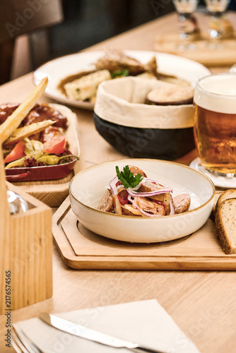 Gourmet dish served on wooden platter with bread and beer in restaurant