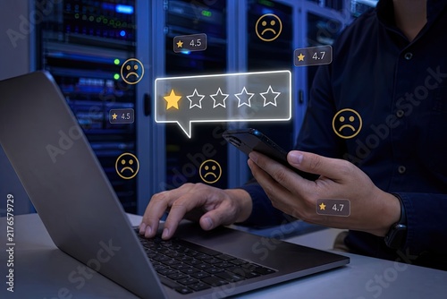 Man using a smartphone and laptop to provide five-star feedback and excellent customer service rating against a data center background.