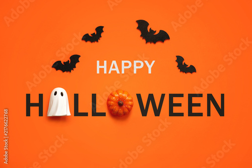 Happy Halloween. Top view of ghost and pumpkin forming the text Happy Halloween with bats