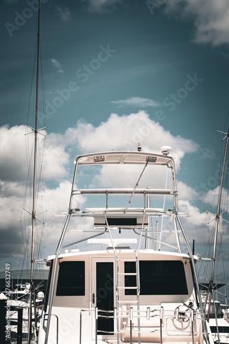 Obraz na płótnie Upper deck of modern superyacht and masts against cloudy sky