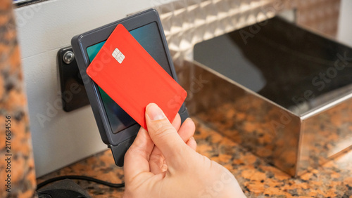 A woman pays for a ride with a bank card at a metro ticket office.