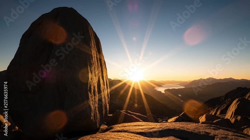 Stunning Sunrise Over Mountains With Large Foreground Boulder And Sunburst
