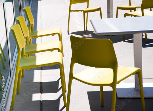 Bild auf Leinwand Yellow Outdoor Chairs and Table on Modern Patio