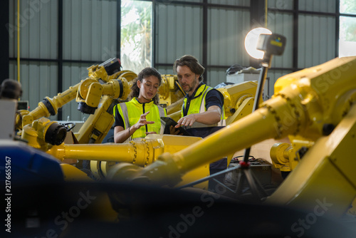 Foto Industrial engineer and technician discussing robotic arm maintenance inside mod