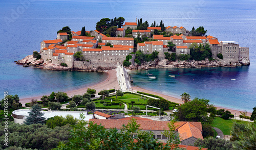 фотографія An elevated view of the historic fortified islet of Sveti Stefan, connected by a