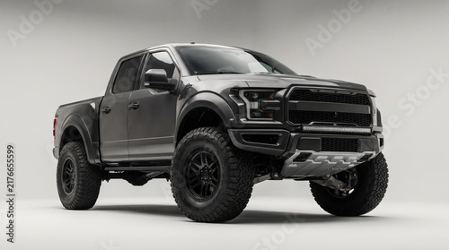Modern dark gray off road pickup truck in a professional studio