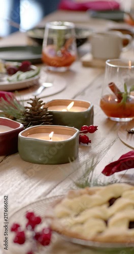Vertical video: Camera moving is revealing candles and pie, flames flickering for Christmas dinner