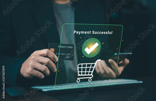 Close up of businessman holding credit card and smartphone with green payment successful icon hologram, online checkout and e-commerce concept.