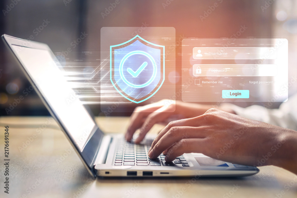 Obraz premium A close-up shot of hands typing on a laptop keyboard emphasizing digital security with a login screen and a protective shield icon representing online safety. Gantry