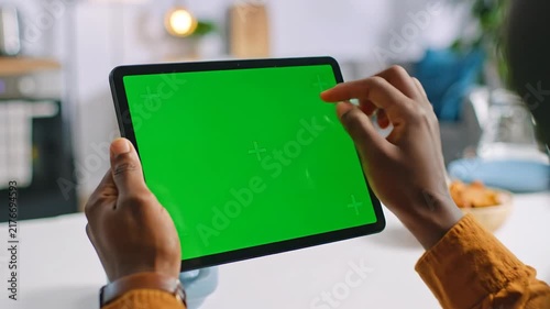 Black man using tablet with green screen mockup