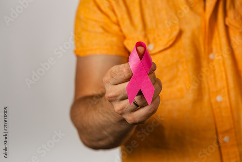 Man holds pink awareness ribbon for healthcare and support