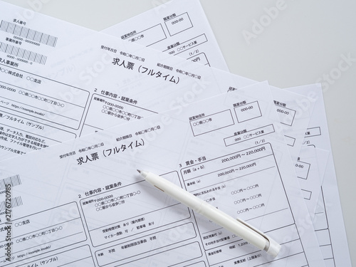 複数の求人票とペンを並べた俯瞰写真（仕事探し・転職・求人比較）掲載内容はオリジナル制作のサンプルイメージ