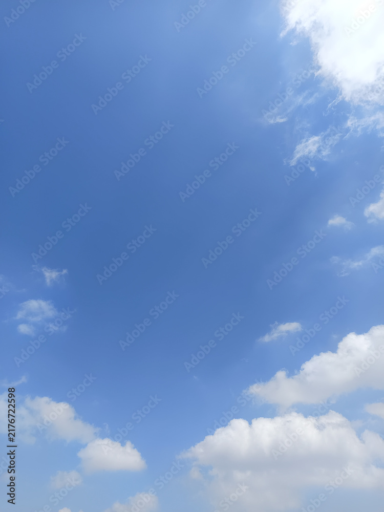 Obraz premium Beautiful blue sky with fluffy white cumulus clouds and delicate wispy clouds, creating a peaceful natural background with ample copy space.