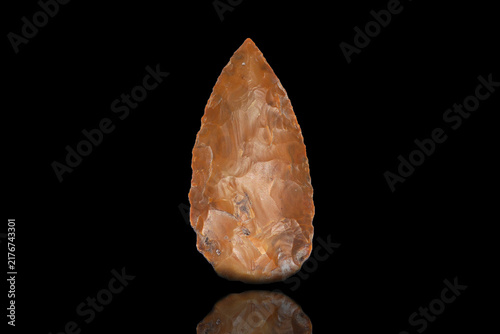 Bild auf Leinwand Ancient stone spearhead from Paleolithic era, prehistoric primitive weapon with sharp flint edge and historical artifact texture