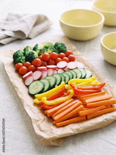 Fresh Raw Vegetable Platter with Sliced Carrots, Cucumber, Radish, Cherry Tomatoes, Broccoli and Bell Peppers on Rustic Parchment Paper for Healthy Diet and Clean Eating Concept Food Photography
