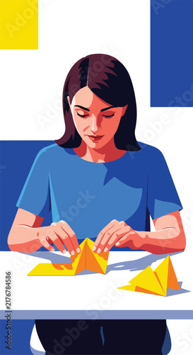 Woman folds yellow paper at a table with abstract shapes