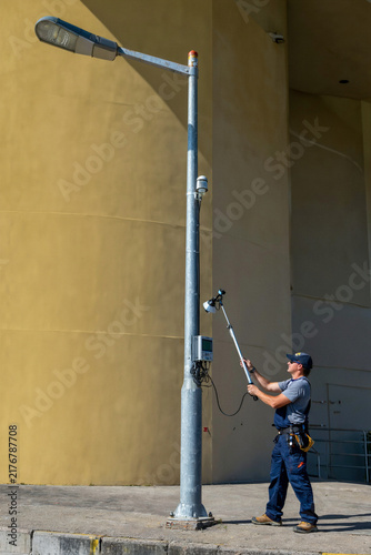 Obraz na płótnie Technician Testing Streetlight Photocell Sensor