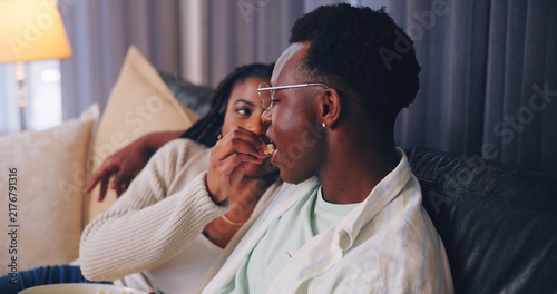 Konstfotografi Streaming, popcorn or couple in home with feeding, movie binge or watching tv on weekend break