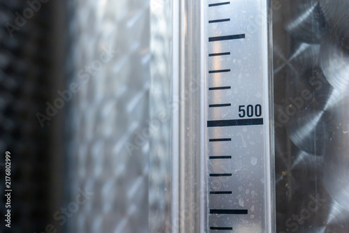 Close up of number 500 on a measurement scale of a stainless steel wine fermentation tank, industrial winery equipment for monitoring liquid volume during wine production.