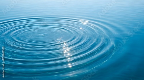 Ripple effect on blue water surface with sunlight