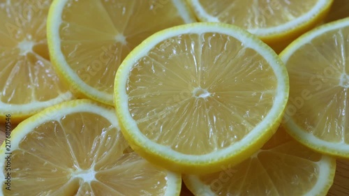 Yellow lemon slices piled togather, close shot. Rotative background. 