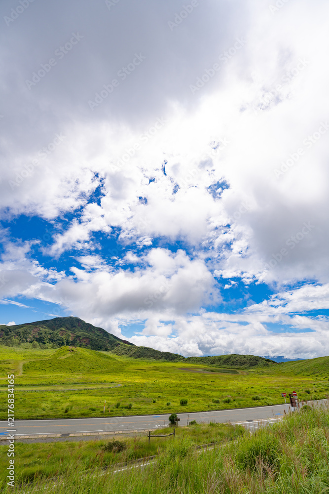 Obraz premium Expansive Aso grassland beneath towering summer clouds