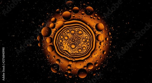 Abstract macro view of vibrant golden oil droplets floating on a deep black liquid surface, creating a cosmic and mesmerizing pattern, ethereal, depth, black