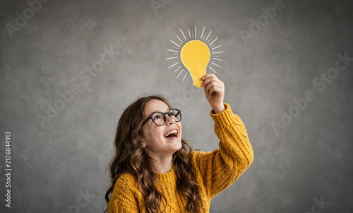 Young Girl Holding Bright Idea Light Bulb