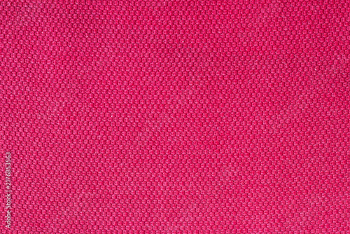 Natural textile surface for design. Pink or red woven fabric. Fabric motif, design, or pattern background. Wallpaper. Copy space, blank, empty. Horizontal photo.