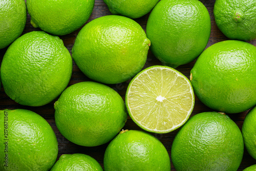 Top view of fresh ripe limes. Bright green background