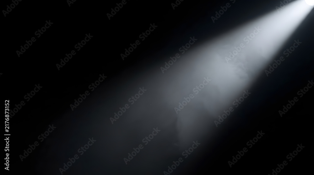 Fototapeta premium A bright white spotlight beam shining through dark misty air creating a dramatic atmospheric effect on a black background