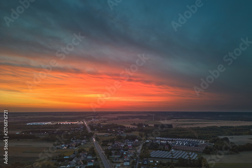 Sunset sky with dramatic clouds and rain over farmland
