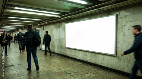Blank billboard in a subway station with people walking by.
